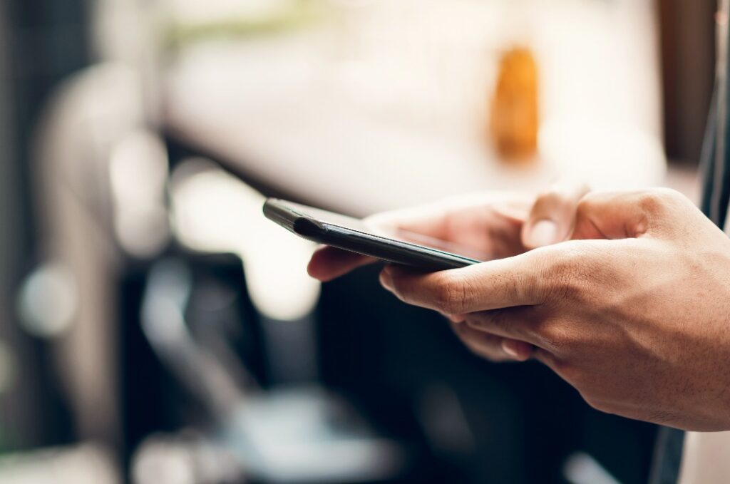 Mann bei der Verwendung eines Smartphones, in der Freizeit. Das Konzept der Nutzung des Telefons ist im täglichen Leben unerlässlich.